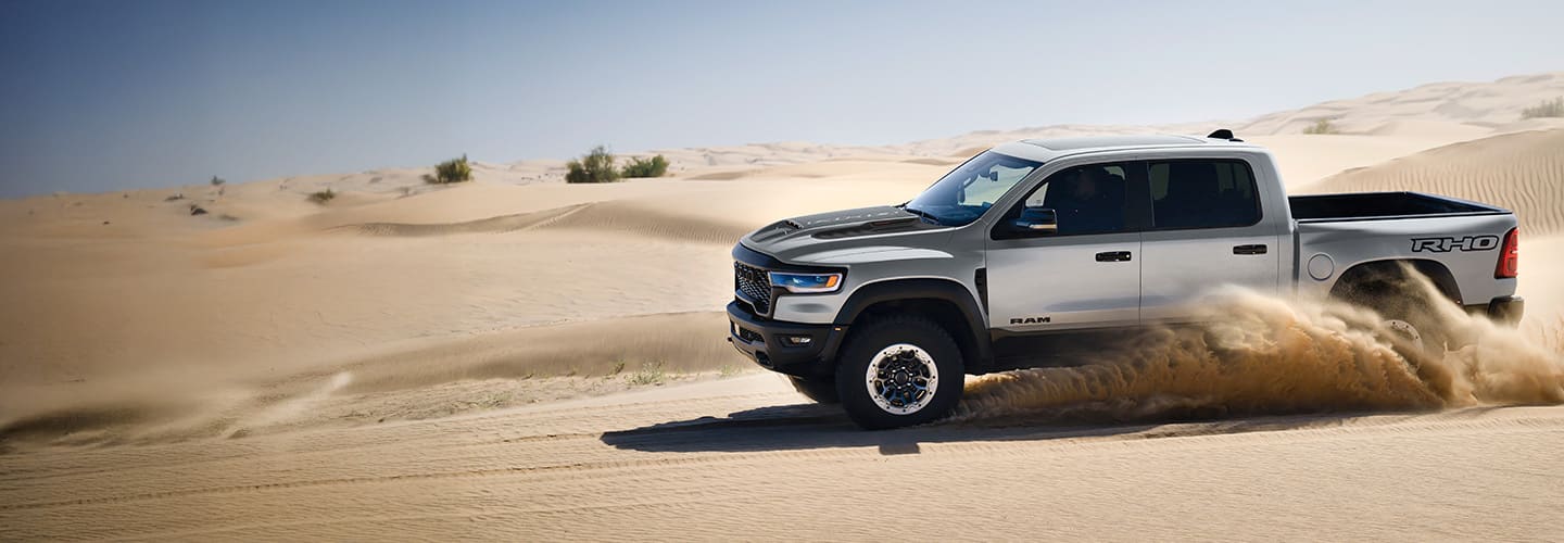 A Ram 1500 RHO truck driving off road in the desert.