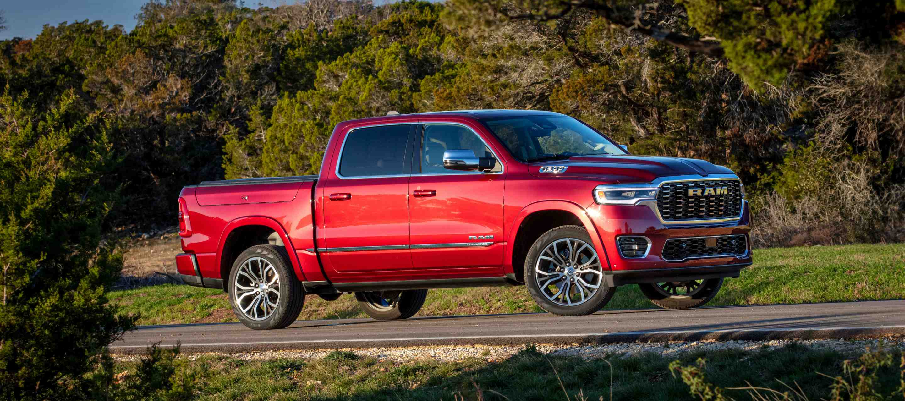 A passenger-side profile of a red 2025 Ram 1500 Tungsten.