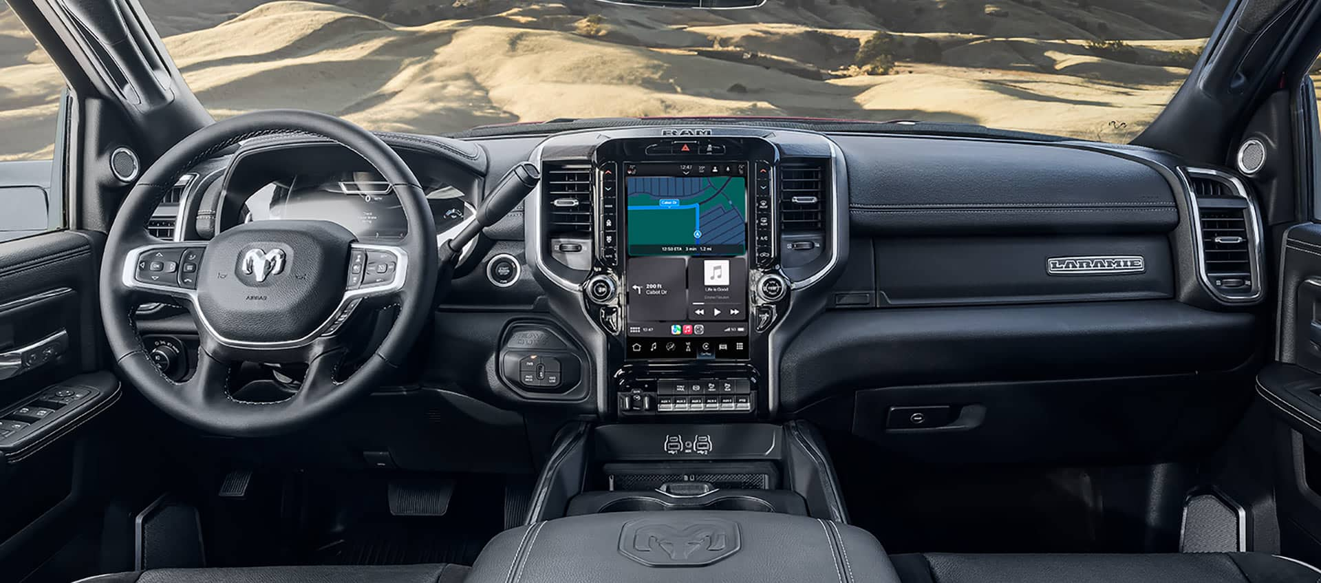 The interior of a 2025 Ram 2500 Laramie from the driver's perspective, demonstrating through the windshield that the vehicle is in the desert.