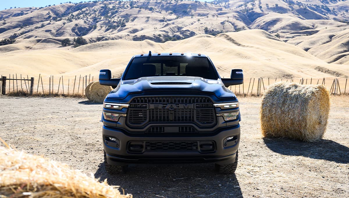 Display A head-on angle of a blue 2025 Ram 2500 Rebel 4x4 parked at a ranch.