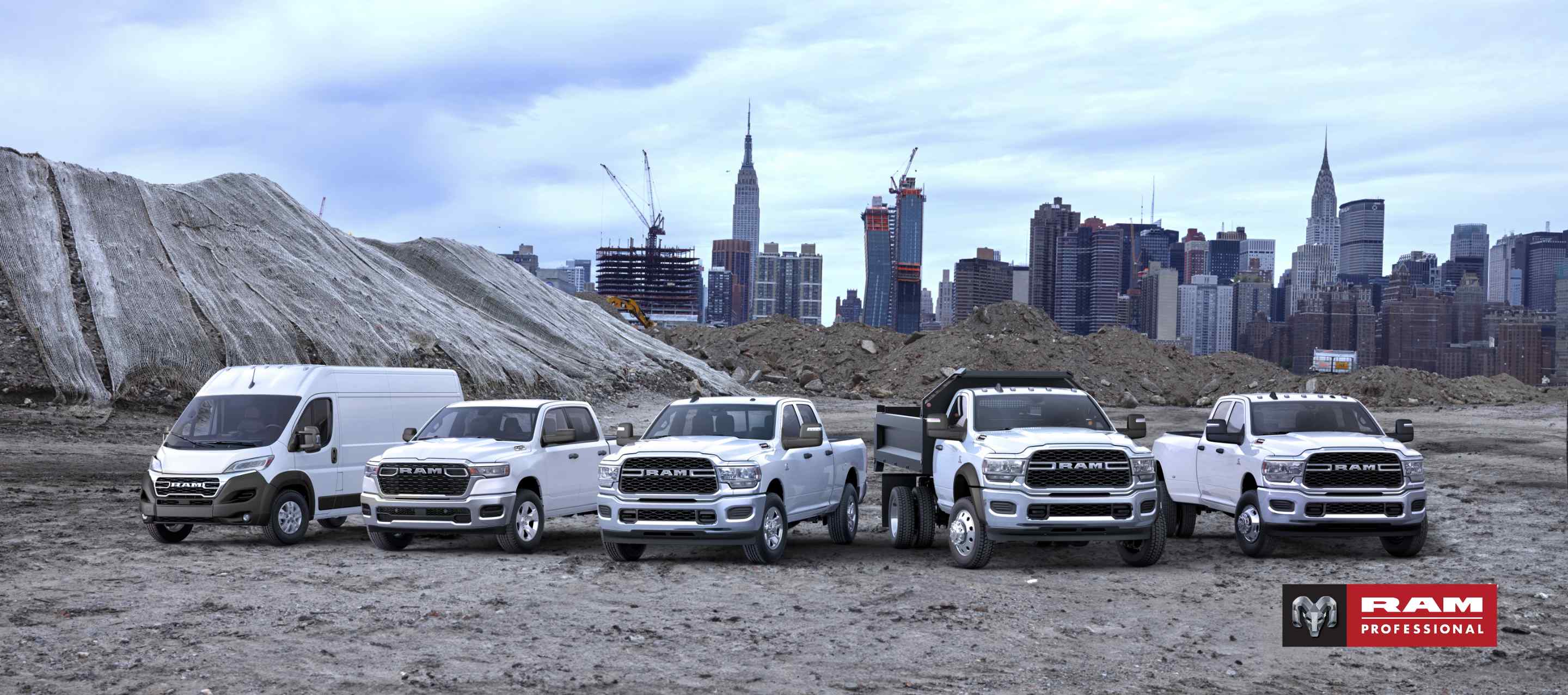 The 2025 Ram Brand lineup all in white, parked side-by-side at at a pre-construction site, with a cityscape in the background. From left to right: a Ram ProMaster 3500 SLT High Roof Cargo Van, a Ram 1500 Tradesman 4x4 Crew Cab, a 2024 Ram 2500 Tradesman 4x4 Crew Cab, a 2024 Ram 5500 Tradesman Chassis Regular Cab with dump body upfit and a 2024 Ram 3500 Tradesman 4x4 Crew Cab. Ram Professional.