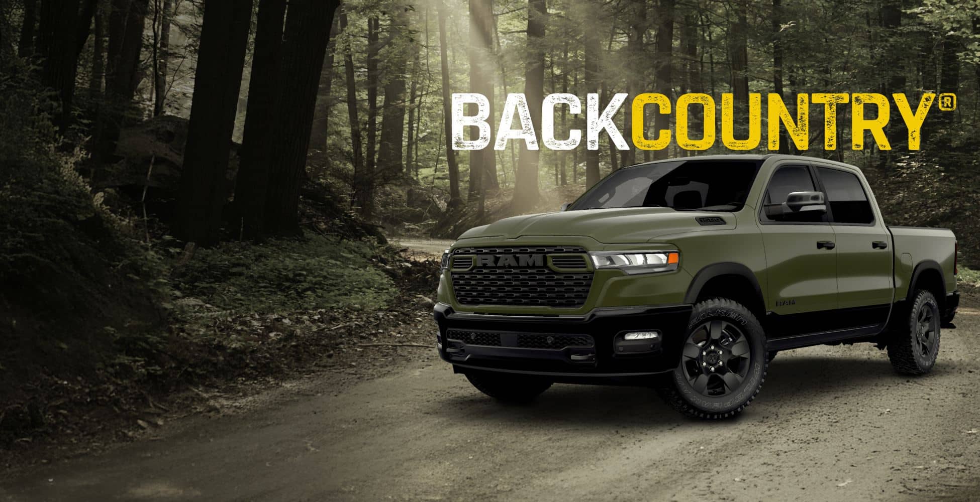 A driver-side front angle of a green Ram 1500 BackCountry 4x4 Crew Cab traveling on a dirt road in a forest. BackCountry.
