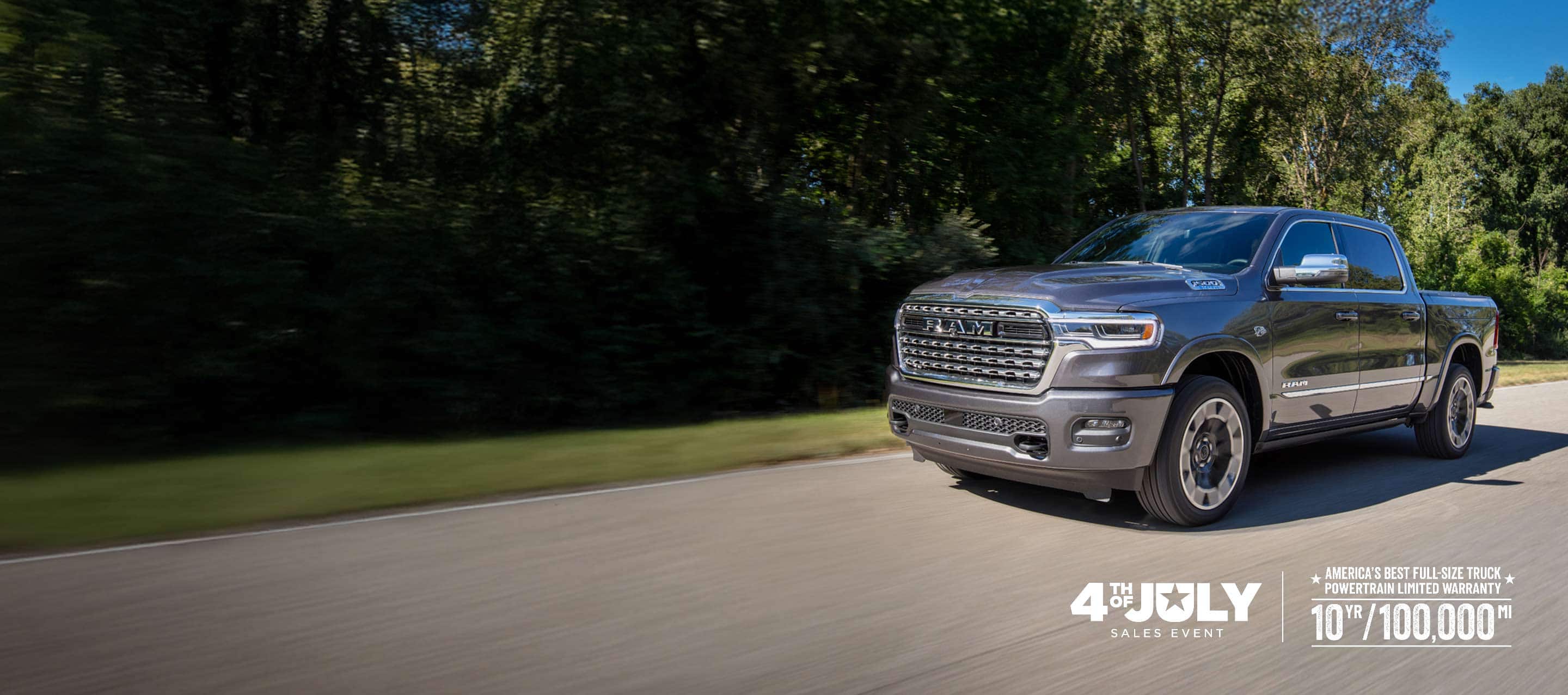A gray 2026 Ram 1500 Limited 4x4 Crew Cab traveling down a country road. 4th of July Sales Event.