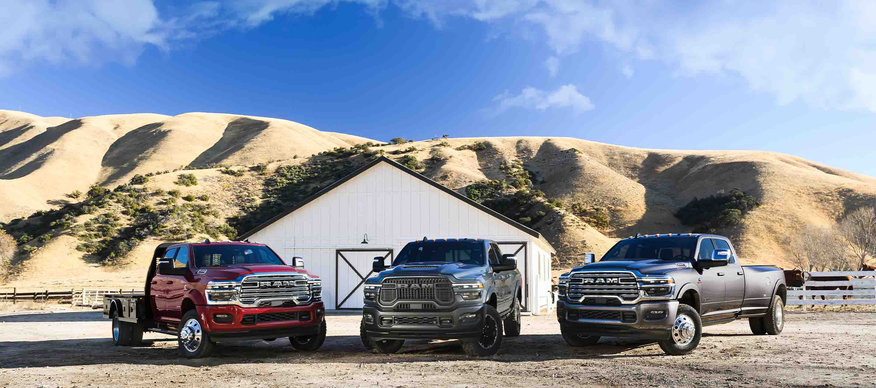 Three 2025 Ram Brand pickups. From left to right: a red Ram Laramie Chassis Cab Crew Cab with a platform upfit, a blue Ram 2500 Rebel Crew Cab and a gray Ram 3500 Limited Longhorn Crew Cab.