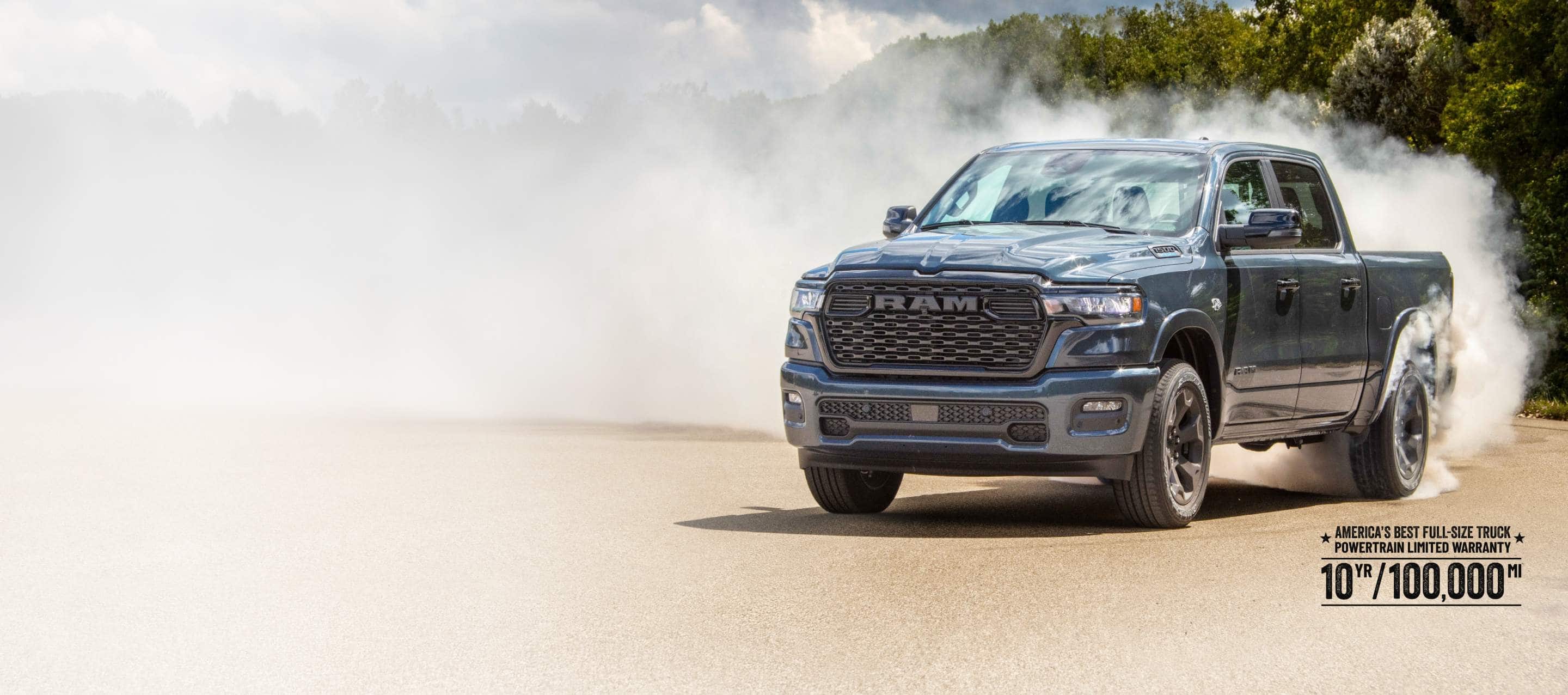 A passenger-side front angle of a blue 2026 Ram 1500 Big Horn 4x4 Crew Cab, with a trail of white smoke billowing from its rear tires. America's Best Full-Size Truck Powertrain Limited Warranty—10 Years/100,000 Miles.
